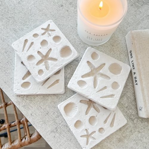 Set of four white shell imprint coasters