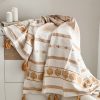 Ochre throw with tassel decoration